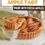 A sliced Easy Apple Tart sits on a glass cake stand, showing layers of fresh apples in a golden crust. A serving utensil lifts one slice.