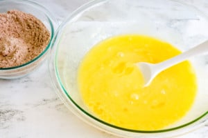 A bowl of melted butter and brown sugar sits on a marble countertop.