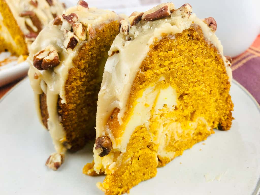 Close-up photo of sliced pumpkin bundt cake with a cream cheese swirl.