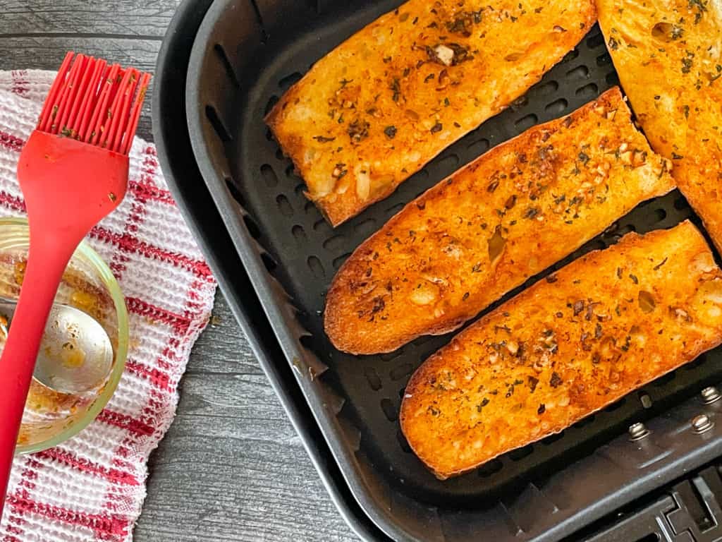 Ari fryer garlic bread in the air fryer basket.