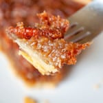 One bite of pecan pie on a fork.