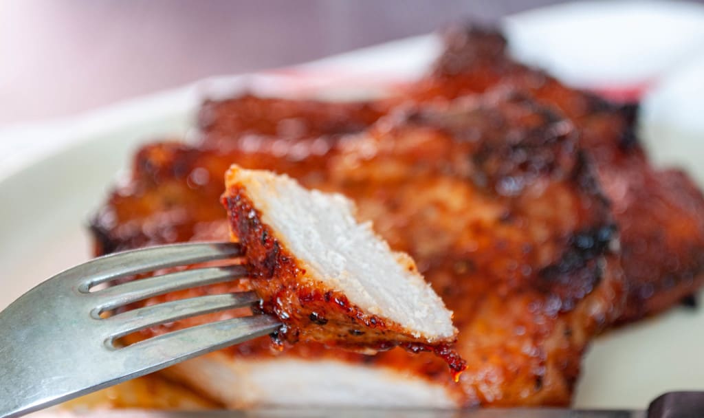 One perfect bite of an Air Fryer Bone-In Pork Chop.