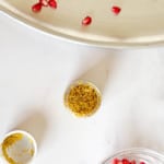 Edible glitters and pomegranate arils in a countertop.