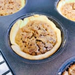 Freshly baked mini pecan pie in a muffin tin.