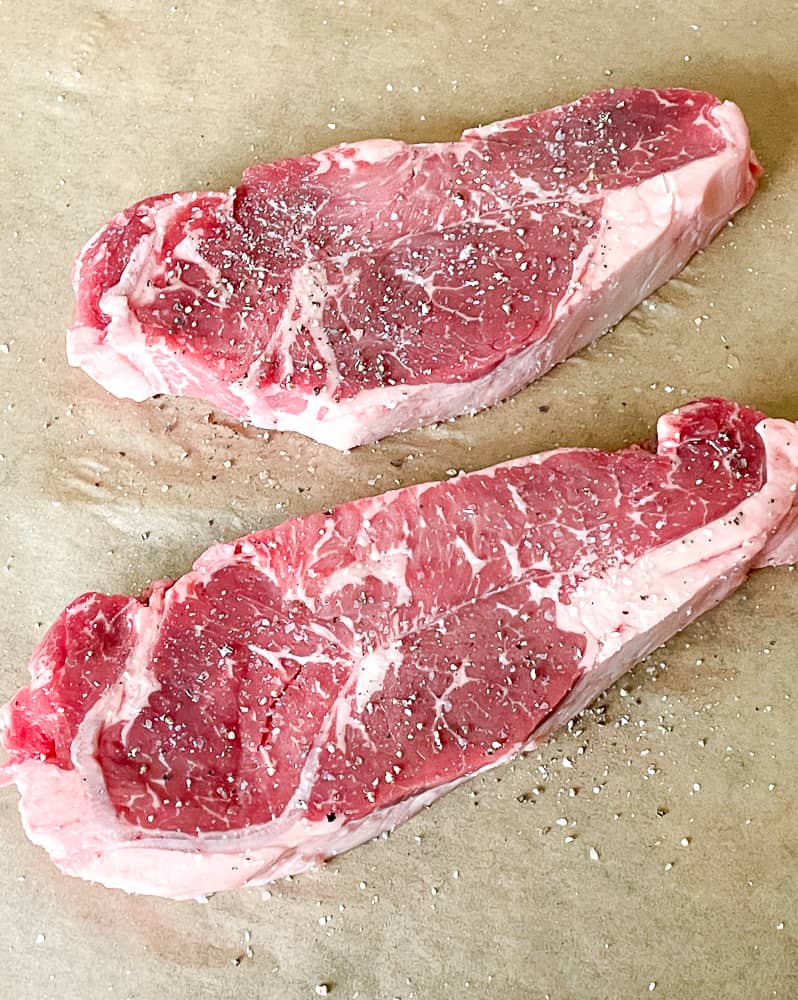 Salt and pepper on new york steaks. 