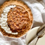 Pecan pumpkin pie topped with whipped cream ready to be served.