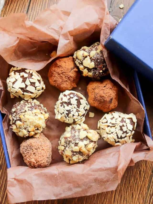 Chocolate truffles in a blue box on a wooden table.