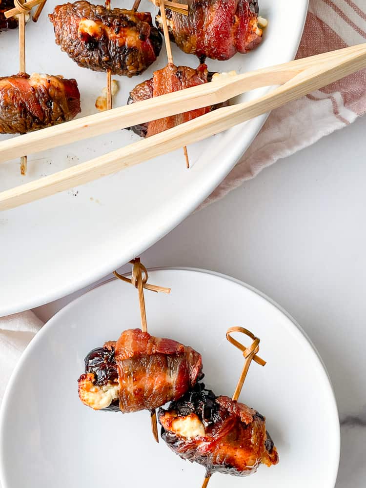 a plate with two bacon wrapped dates.