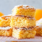 Pin Image for Lemon Brownies featuring a stack of lemon brownies on a baking rack.