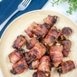 Featured photo for bacon wrapped dates. Dates on a plate with a fork and greenery.