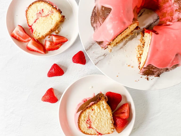 Sweet strawberry pound cake on plates, each with a slice served alongside fresh strawberries.
