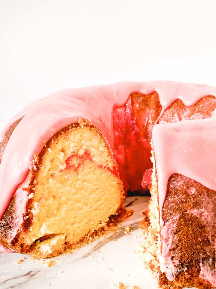Sliced strawberry cream cheese pound cake with a swirl of strawberry. 