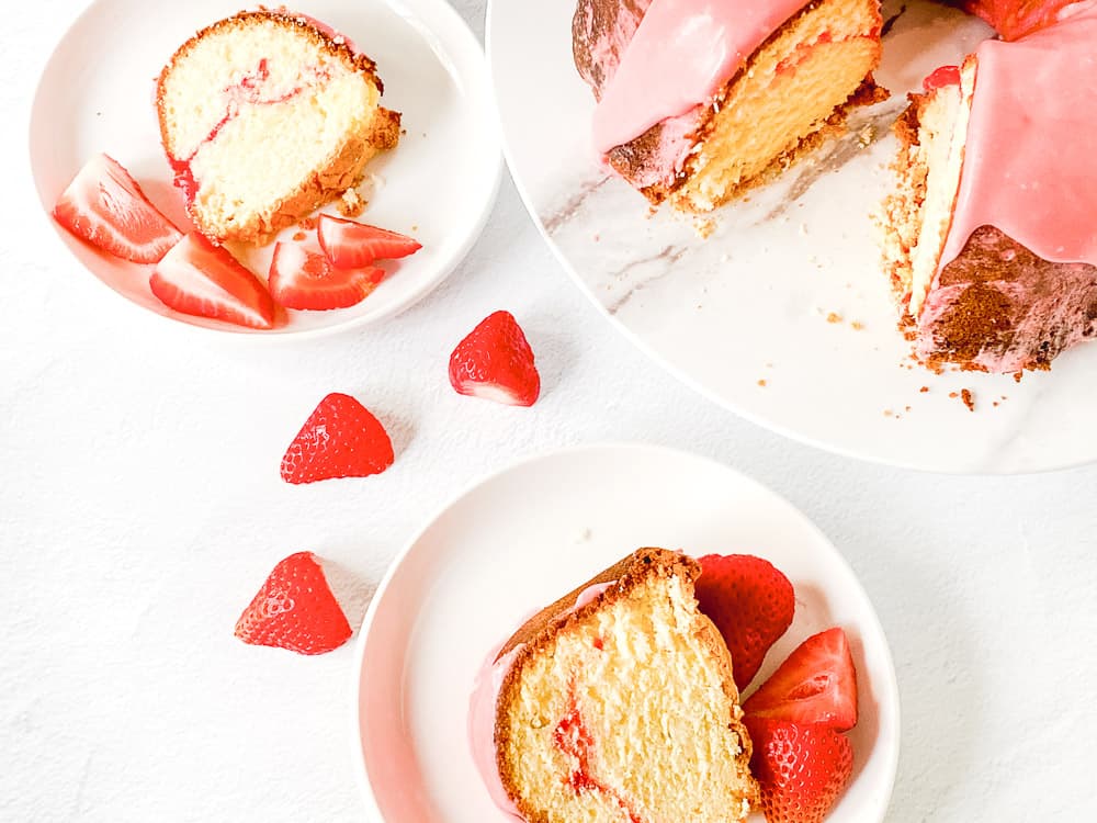 Sweet strawberry pound cake on plates, each with a slice served alongside fresh strawberries.