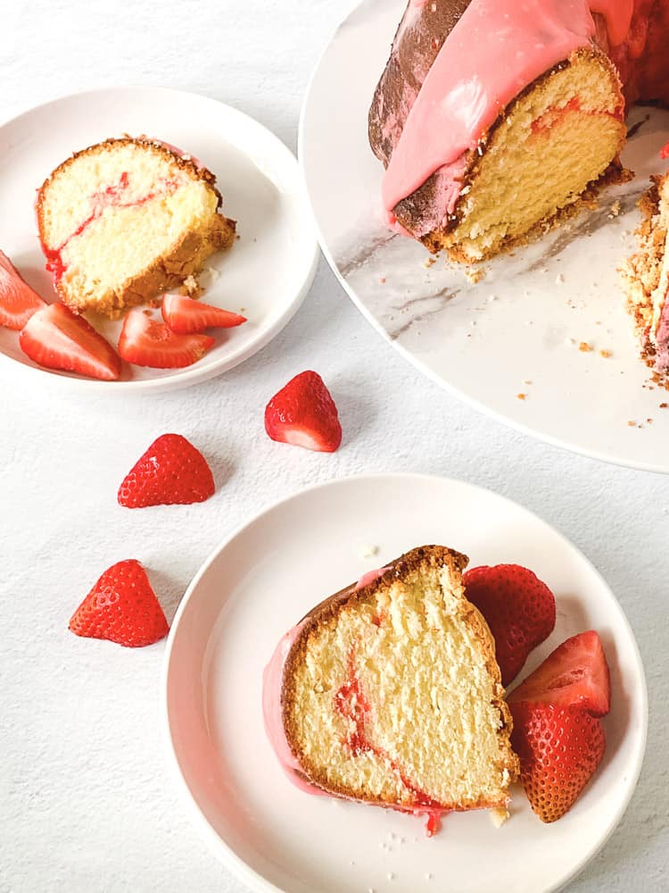 Sweet strawberry pound cake on plates, each with a slice served alongside fresh strawberries.