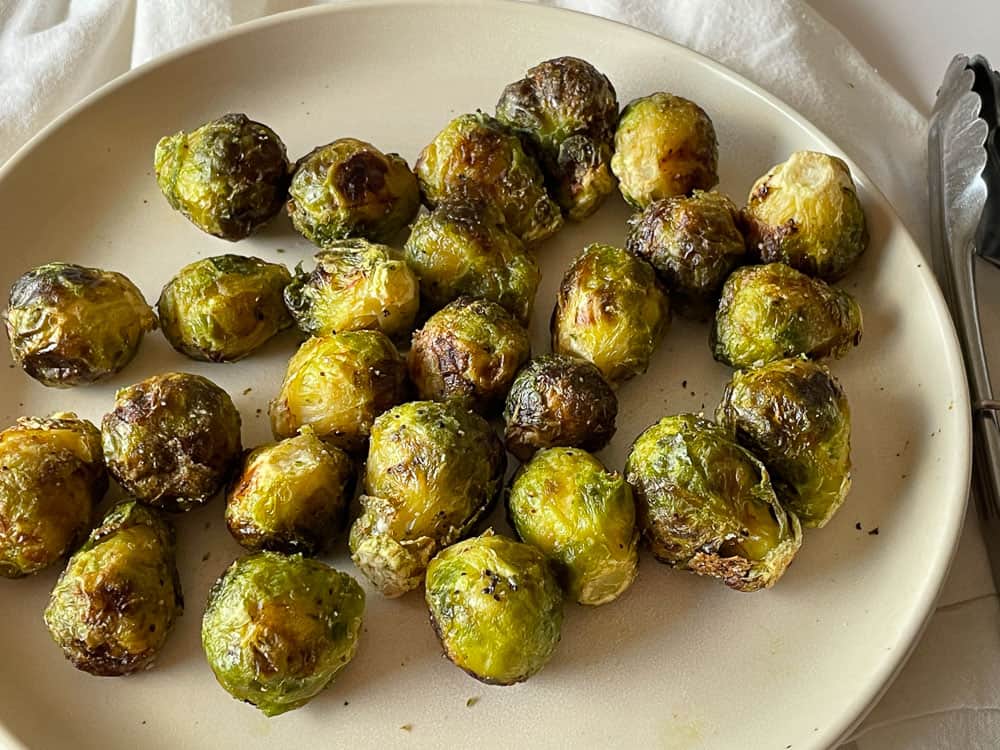 A plate full of air fryer roasted brusslel sprouts.