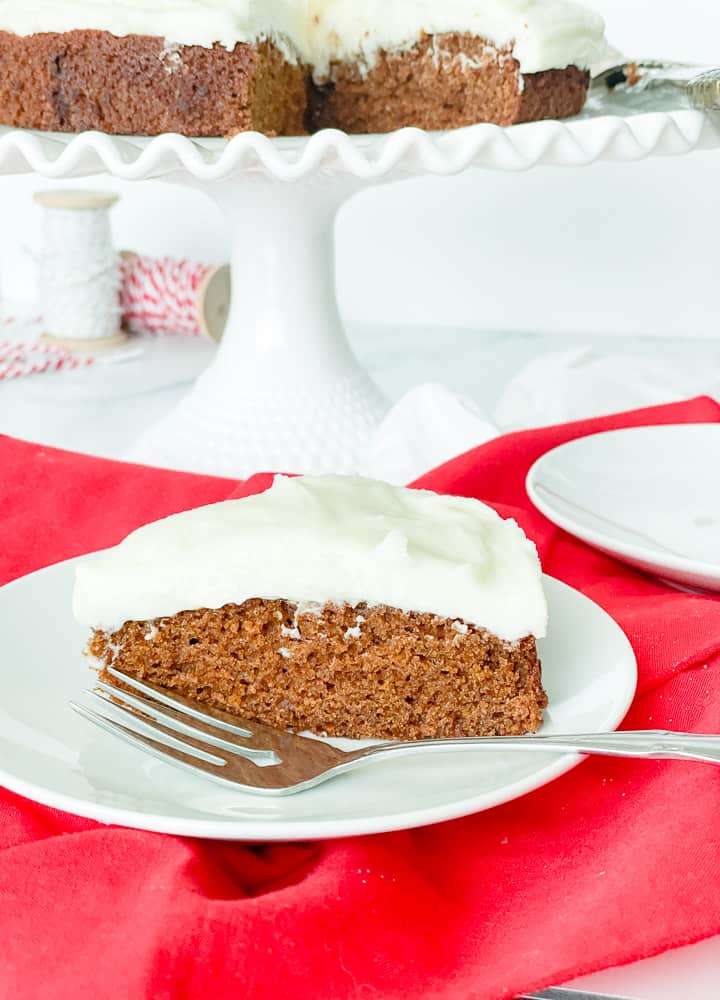 A slice of gingerbread cake, on a plate with a fork.