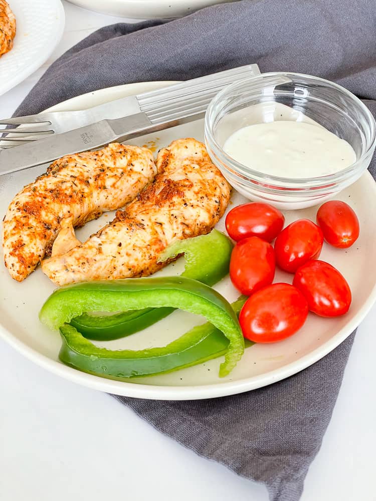 A Plate of air fryer grilled chicken with fresh vegetables and dip. 