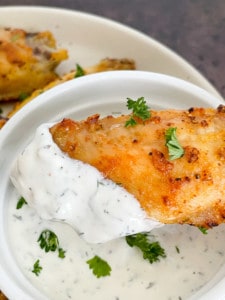 Dipping a Lemon Pepper Chicken Wing in dip.