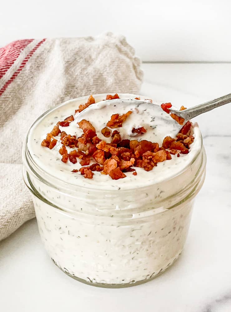 Bacon Ranch Dressing in a jar with a spoon in it.