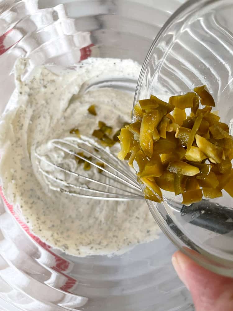 Mixing jalapeños into the ranch dressing.