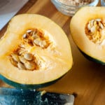 Cleaning winter squash, squash, knife, and cutting board.