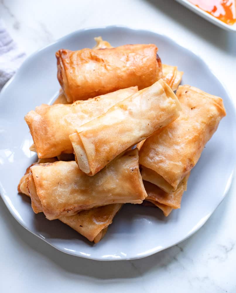 Stack of buffalo chicken egg rolls on a plate.