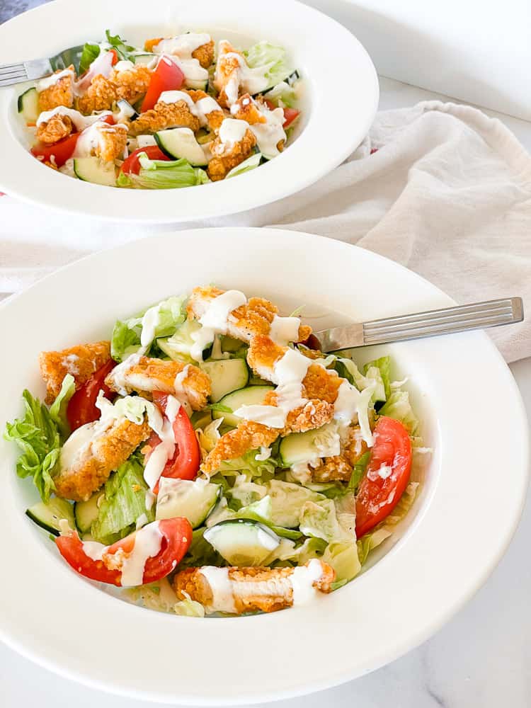 Fresh salad with chicken on top.