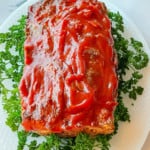 Easy Oven Meatloaf with parsley on a serving platter.