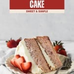 A slice of delectable strawberry cake with white frosting, garnished with fresh strawberries, sits on a plate with a fork.