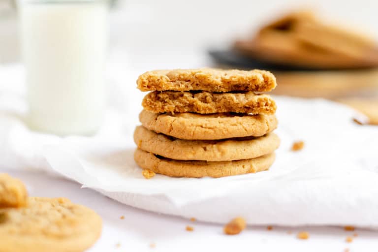 A stack of biscoff cookies with one broken in half.