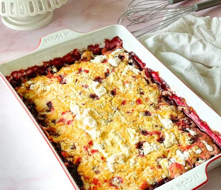A full cherry dump cake with a towel on one side.
