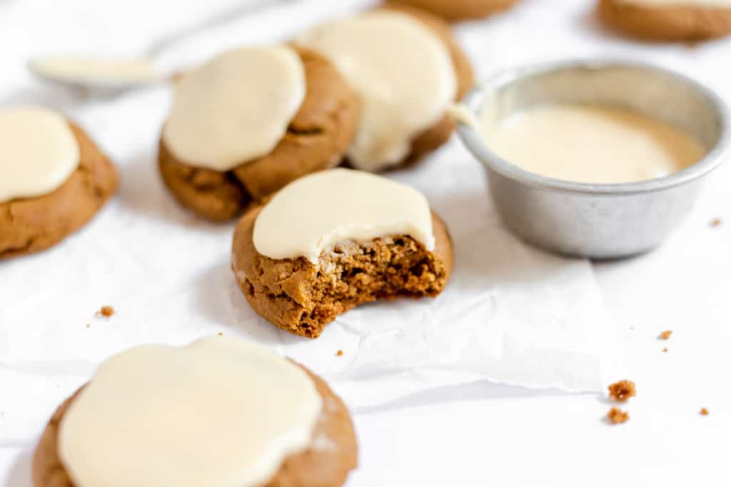 An iced molasses cookie with a bite taken out of it.