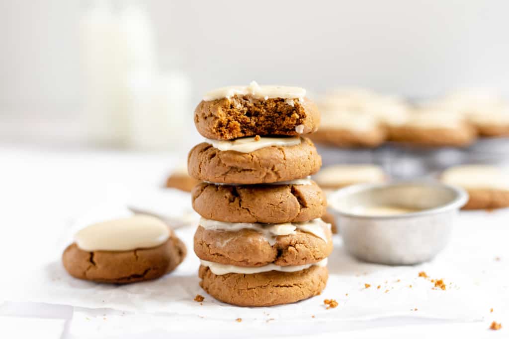 Stacked molasses cookies one with a bite taken out of it. 