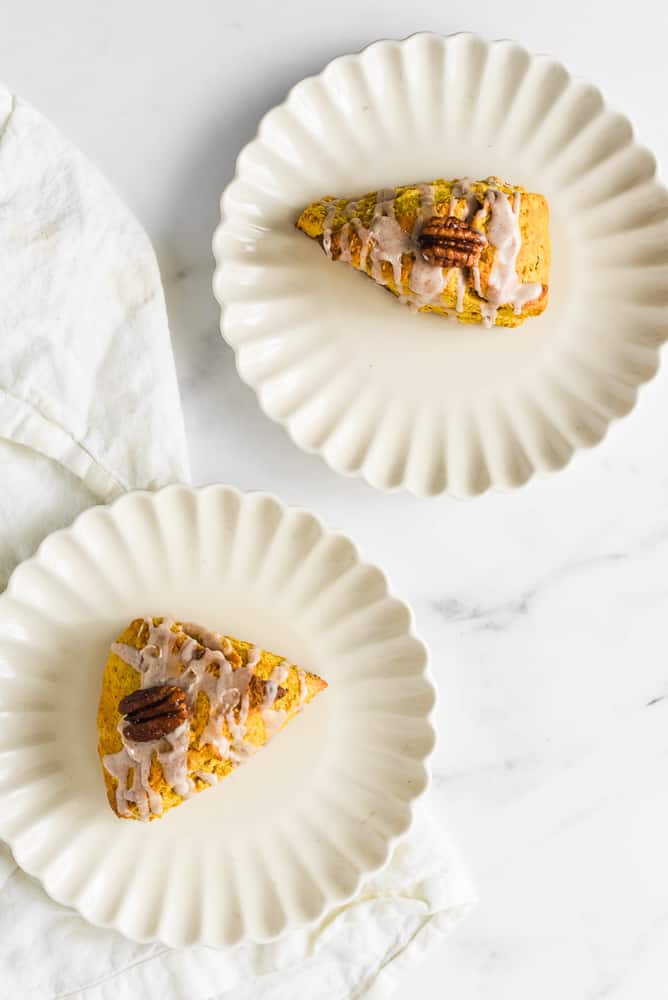 Two pumpkin scones on plates.