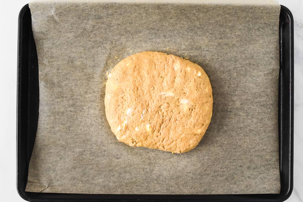 Pumpkin scone dough patted out into a circle. 