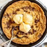 Pizookie with ice cream and spoons in a cast-iron skillet.