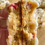 A rhubarb cookie broken in half so you can see the layers of cookie, streusel, and icing!
