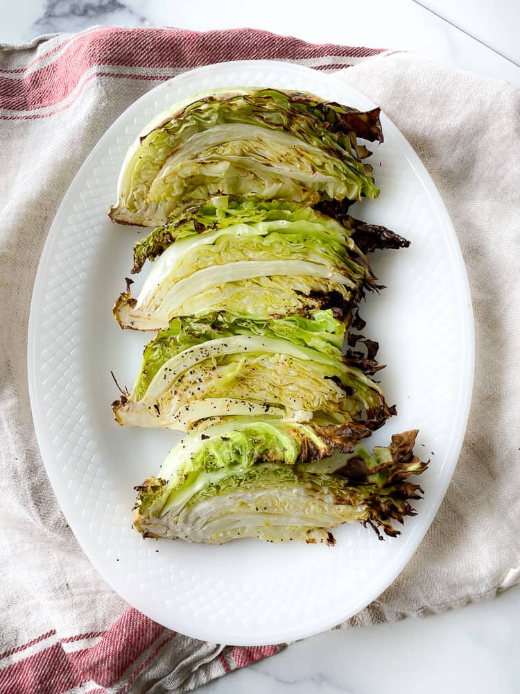 Simple Air Fryer Cabbage on a serving platter and dish towel.