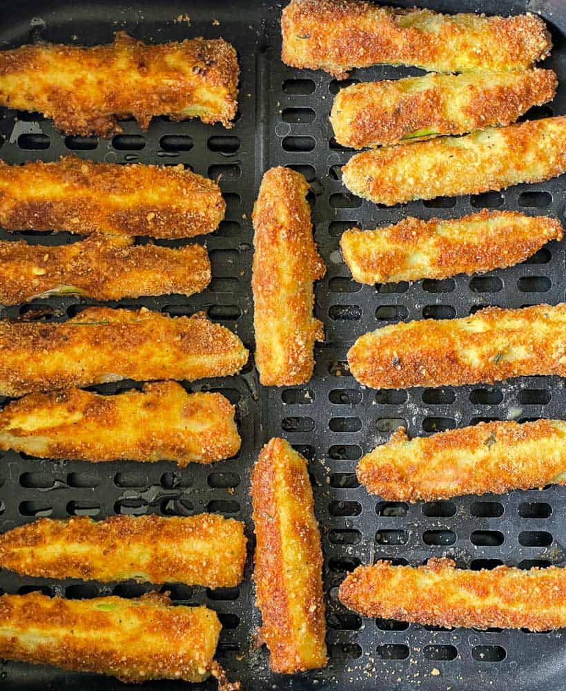 Fried zucchini in the air fryer basket.