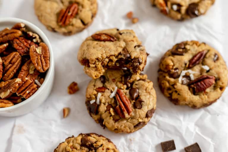 Brown butter cowboy cookies with pecans and chocolate chunks on a [parchment paper.
