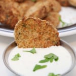 Dipping fried pickles in a dip or dressing.