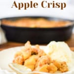 Pin graphic for Apple Crisp. A plate of crisp in front of a cast iron skillet.