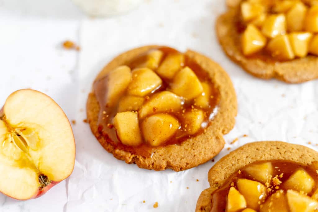 Close-up of apple pie cookies with fresh apple on the side.