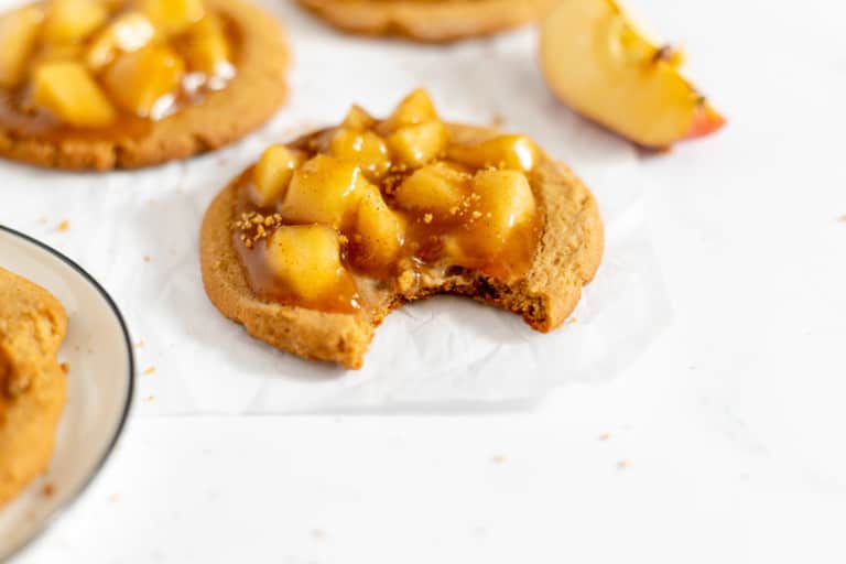 Close-up of an apple pie cookie with a bite taken out.