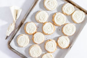Frosted cookies on baking sheet.