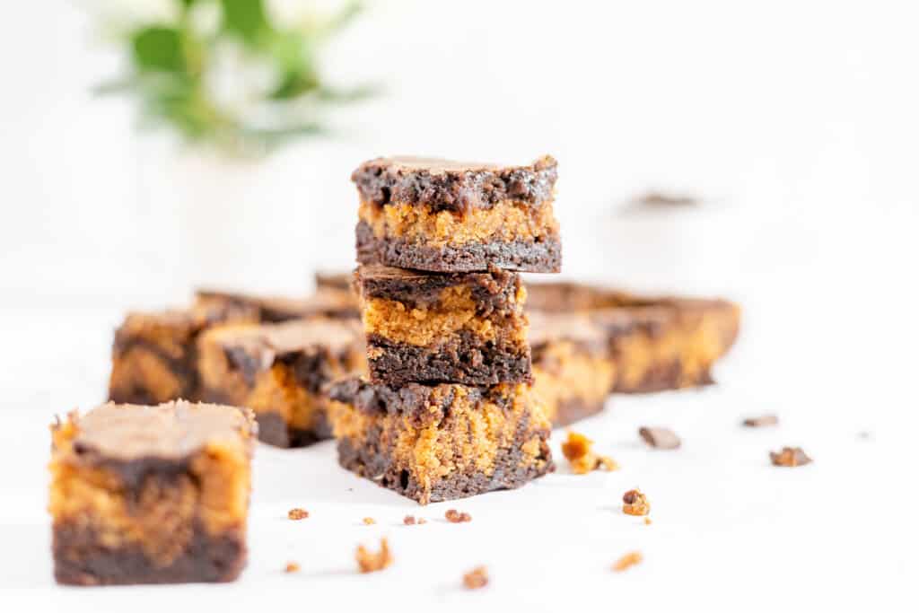 A stack of easy pumpkin brownies with the rest of it in the background.