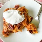 A piece of pumpkin cake on a plate with whipped cream on top.