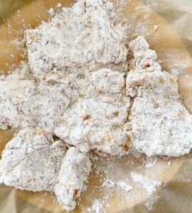 Plate of floured chicken pieces.