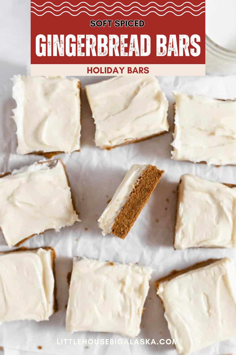 Top-down view of eight frosted Gingerbread Cookie Bars on parchment paper, with one bar turned on its side to show the interior. The label above reads "Soft Spiced Gingerbread Bars.