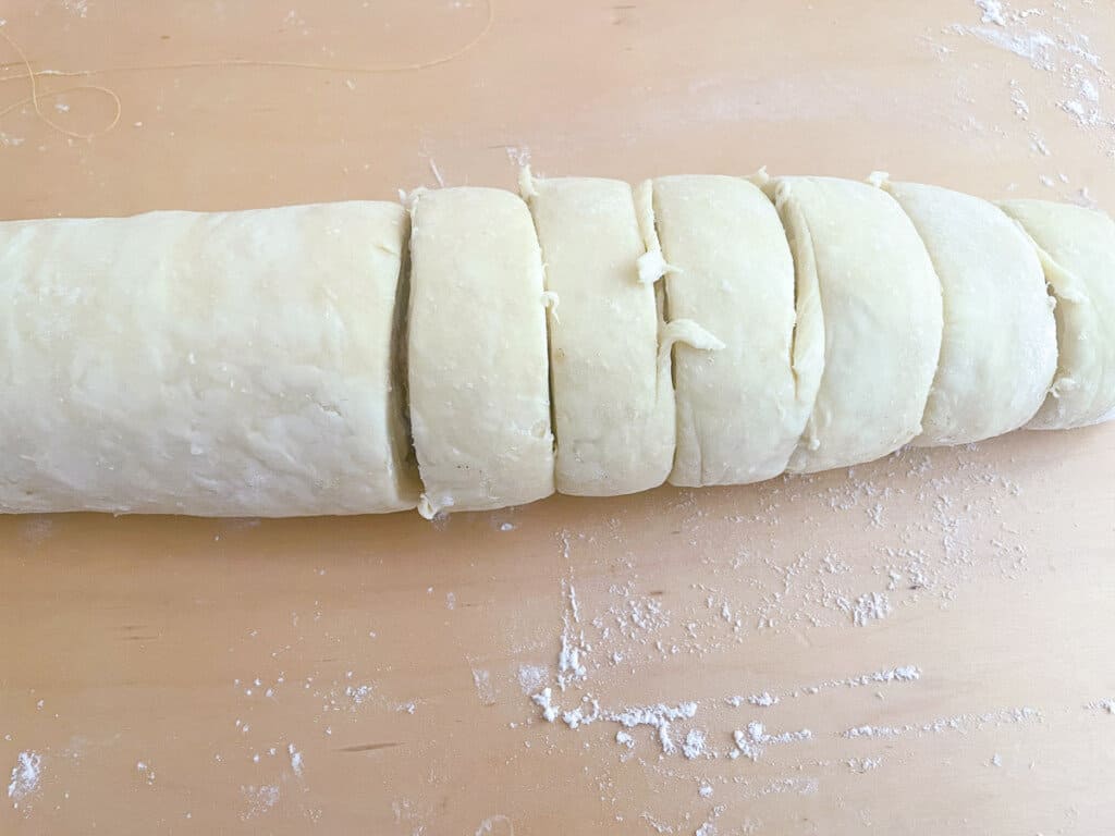 Cutting rolls from a dough log using thread.